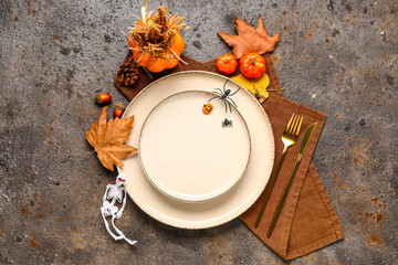 Autumn table setting with pumpkins and leaves on dark grunge background