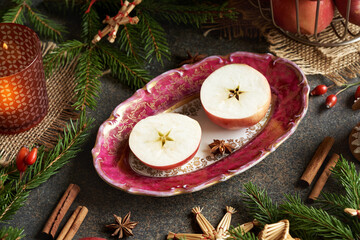 Fototapeta na wymiar Two halves of an apple with a star in the middle with Christmas decoration