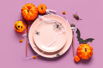Halloween table setting with pumpkins and spiders on purple background