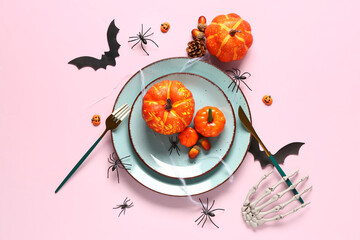 Halloween table setting with pumpkins and spiders on pink background - obrazy, fototapety, plakaty