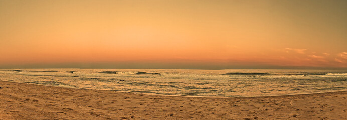 Panoramic beautiful beaches of Outerbanks lit up by the sun behind the morning horizon, NC, USA
