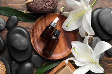 Composition with bottles of cosmetic products, spa accessories and lily flowers on wooden background