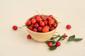 Bowl with fresh rose hip berries on white background