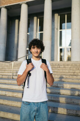 Portrait of young student boy with curly hair smiling and looking at camera 