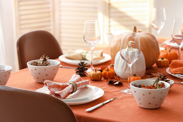 Autumn table setting with pumpkins and pine cones