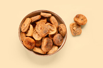 Bowl with sweet dried figs on yellow background
