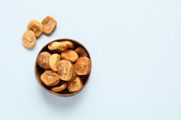 Bowl with sweet dried figs on blue background