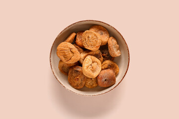 Bowl with sweet dried figs on beige background