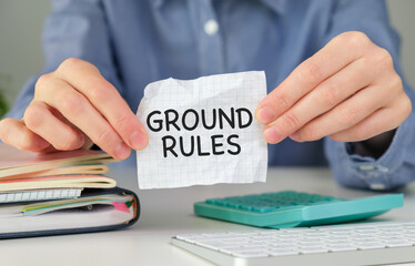 Closeup on business woman holding a card with text GROUND RULES, business concept image with soft...