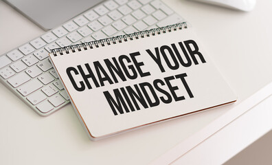 Change Your Mindset. wooden table. torn page from a notebook on two notebooks with text