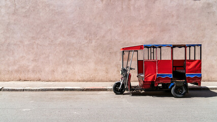 Tok tok vehicle parked in the old city of Marrakesh, Morocco. These tricycle vehicles are used mostly for tourism and public transportation purposes - obrazy, fototapety, plakaty