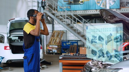 Mechanic in repair shop using advanced virtual reality technology software to visualize car engine...