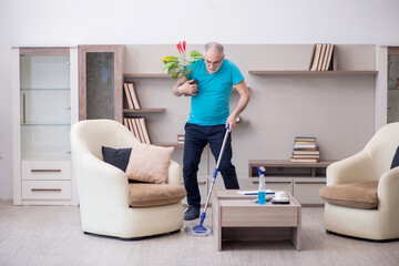 Old male contractor cleaning the house