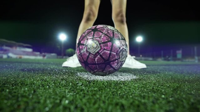 Girl legs in front of a football ball ready to hit it