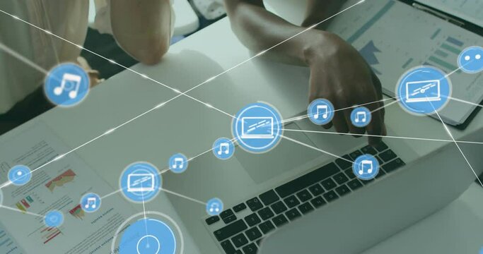 Animation of connected icons, overhead view of diverse coworkers analyzing reports on desk