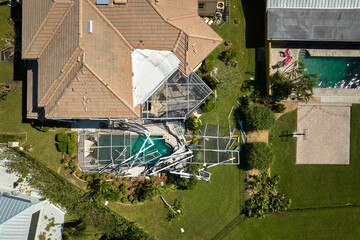 Hurricane Ian destroyed house roof in Florida residential area. Natural disaster and its...
