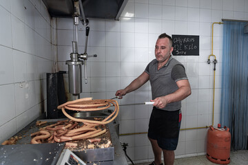 Cocinero sacando masa frita con los palos de churrero para hacer los churos. Los churros son un dulce frito típico español para desayunos y meriendas.