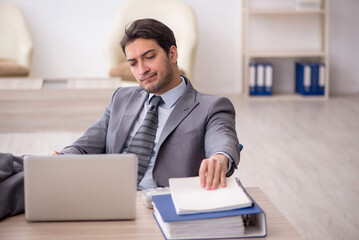 Naklejka premium Young male employee working in the office