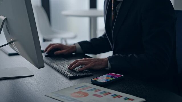 オフィスでパソコンを使って作業する外国人ビジネスマン