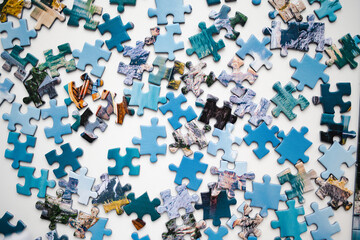 Playing puzzles at home. Connecting jigsaw puzzle pieces in a living room table.