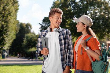 Happy young students spending time together in park