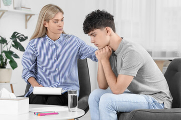 Psychologist working with teenage boy in office. Teenager problems