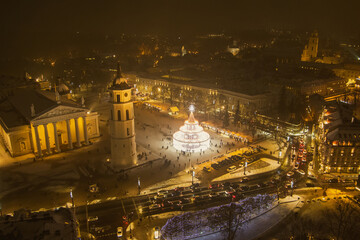 Fototapeta na wymiar Beautiful aerial view of decorated and illuminated Christmas tree on the Cathedral Square at night in Vilnius. Celebrating Christmas and New Year in Lithuania.