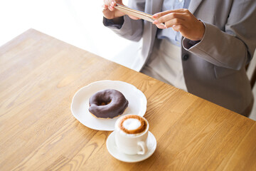 カフェで写真を撮るアジア人女性
