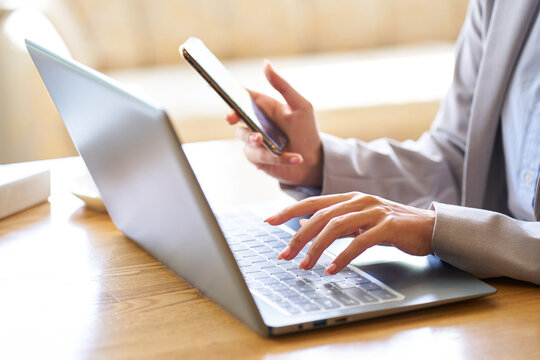 カフェでパソコンを操作するアジア人女性の手元