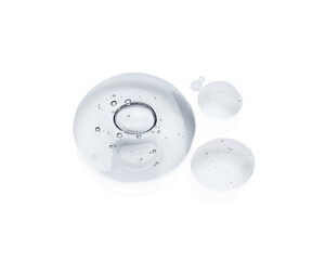 Drops of cosmetic oil on reflective surface, above view