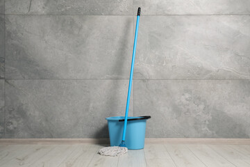 Mop and plastic bucket indoors. Cleaning floor © New Africa