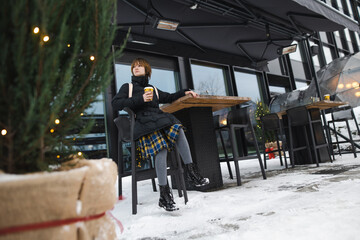 Cute teenage girl with takeaway coffee cup on winter day. Teenager kid drinking hot beverage on chilly day.