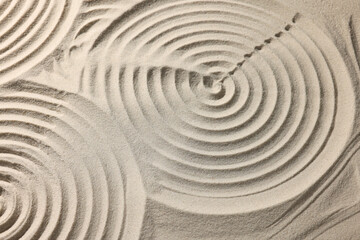 Beautiful spirals on sand, closeup. Zen garden