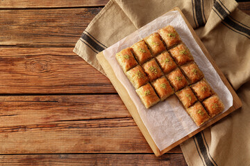 Delicious sweet baklava on wooden table, top view. Space for text