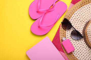 Flat lay composition with beach accessories on yellow background. Space for text