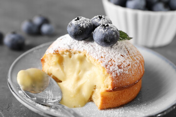 Tasty vanilla fondant with white chocolate and blueberries on grey table, closeup