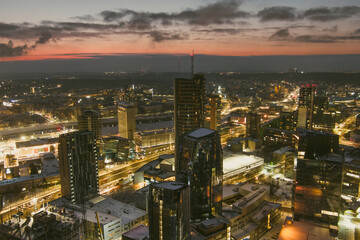 Fototapeta premium Beautiful aerial evening view of illuminated business district in Vilnius. Winter sunset in capital of Lithuania.