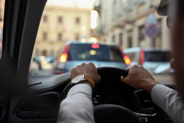 Stuck in traffic jam. Driver holding hands on steering wheel in car, closeup