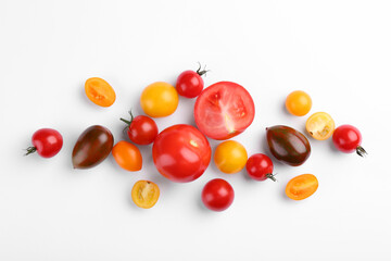Flat lay composition with different whole and cut tomatoes on white background