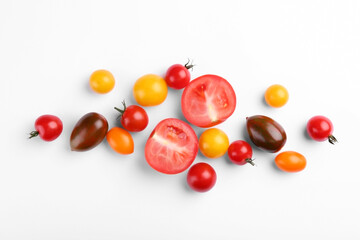 Flat lay composition with different whole and cut tomatoes on white background