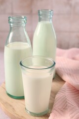 Glassware with tasty milk on table, closeup