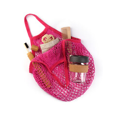 Mesh bag with different items isolated on white, top view. Conscious consumption