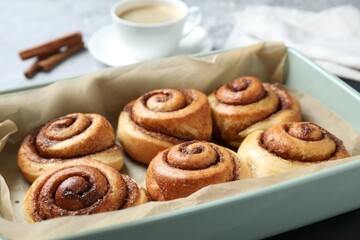 Baking dish with tasty cinnamon rolls on table, closeup