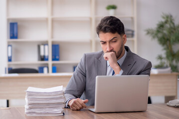 Fototapeta premium Young male employee and too much work in the office