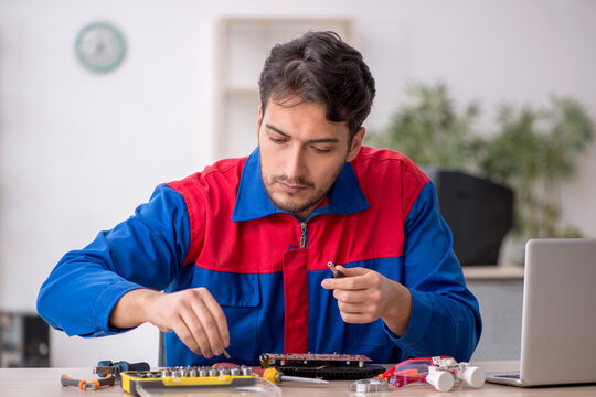 Young male repairman repairing computer - Powered by Adobe