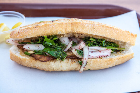 Turkish balik ekmek sandwich of a filet of grilled fish served inside a bun of Turkish bread.