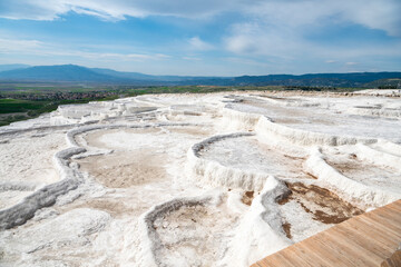 White terraces (natural travertine formations and hot pools) in Pamukkale, Turkey. The terraces are...
