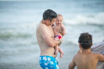Happy Fathers day. Father and his two sons swim on the ocean. Dad and him Child together enjoying sunset. Loving single father hugs cute little son.