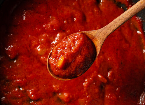 Scoop up the tomato sauce in the pan with a spoon.