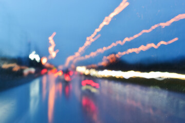light of car on road in the night, blurred traffic jam background with rain